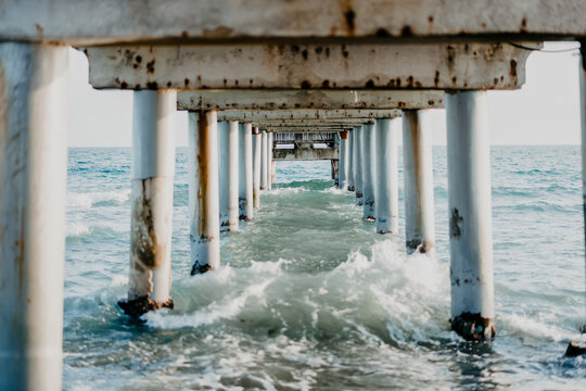 Rusty pier with crashing ocean waves at spanish coast