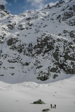 Snowshoeing with dog near rocky snowy mountain landscape