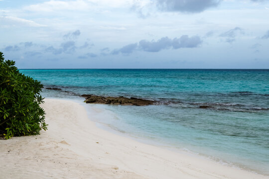 Beach shoreline with turquoise water and rock formation in a beach