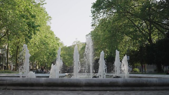 A fountain with splashing water in Cologne, Germany. The water is spraying in different directions in slow motion