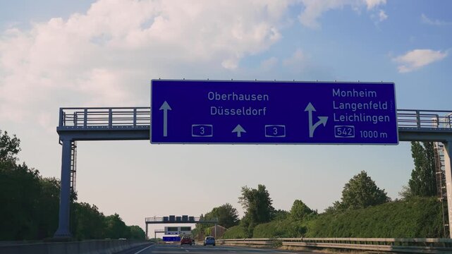 Cologne, Germany - Jul 20, 2023: Pov drive at highway with a blue direction sign sign that says "Dusseldorf" on it.