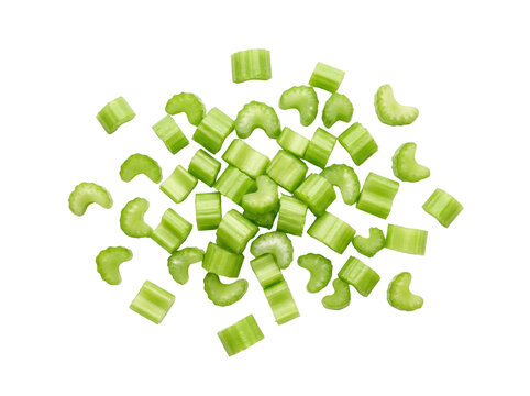 Freshly Chopped Celery Pieces Scattered on a White Background.