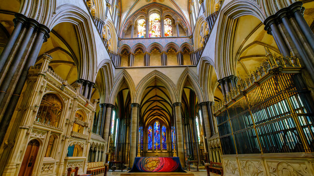 Vibrant stained glass windows illuminating a grand church interior, conveying a sense of spiritual wonder and awe