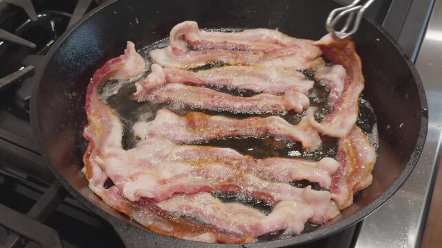 Sizzling bacon frying in a cast iron skillet