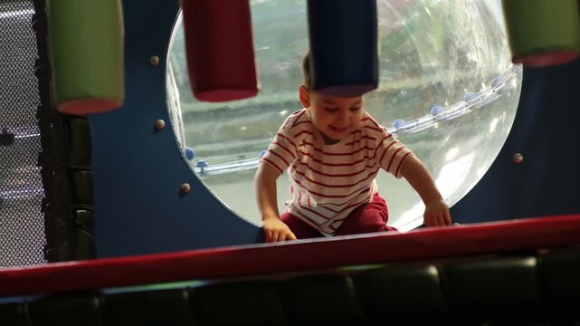 Boy exploring hanging foam obstacles indoors
