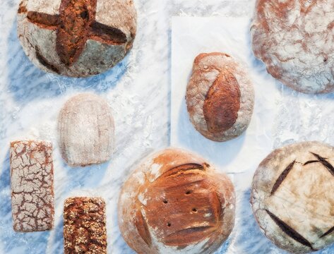 Assorted sourdough and grain bread loaves dusted with flour