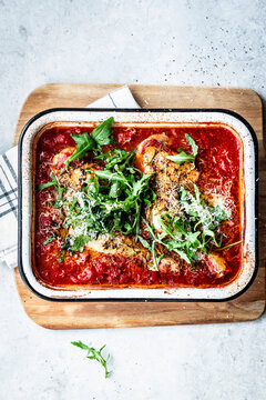 Crispy chicken in tomato sauce with arugula and grated cheese