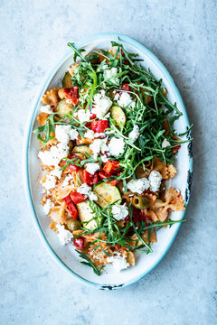 Lukewarm pasta salad with farfalle, Summer vegetables, arugula