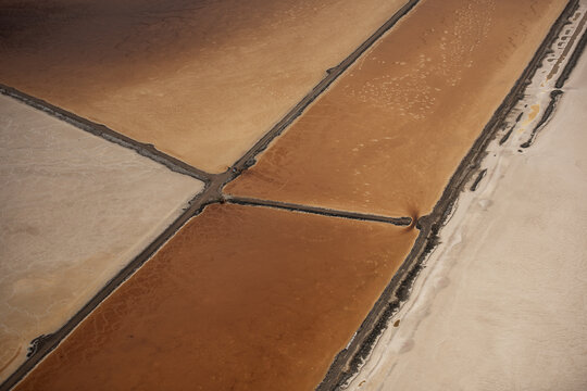 Aerial view of Great Salt Lake showing colorful evaporation ponds with distinct geometric shapes and textured salt crusts in Salt Lake City, Utah, United States.