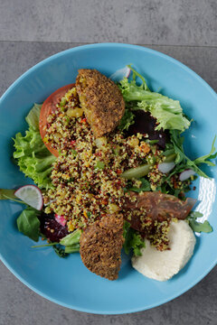 Quinoa salad with vegan patties and hummus