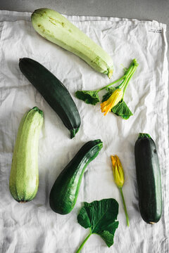 Fresh zucchinis with yellow Zucchini flowers and leaves on white cloth
