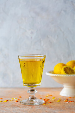 Lemon cordial drink in decorative embossed glass with fresh lemons