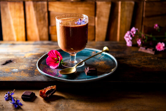 Chocolate smoothie served with dark chocolate pieces and date fruit