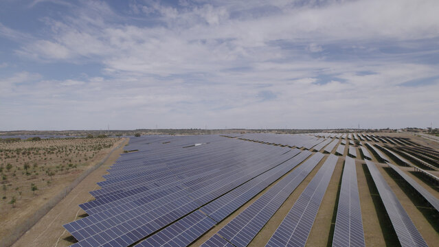 Aerial view of a large solar farm with rows of photovoltaic panels in the rural landscape of Ourique, Beja District, Portugal.
