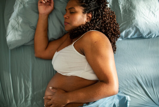 Pregnant woman sleeping on her side in bed