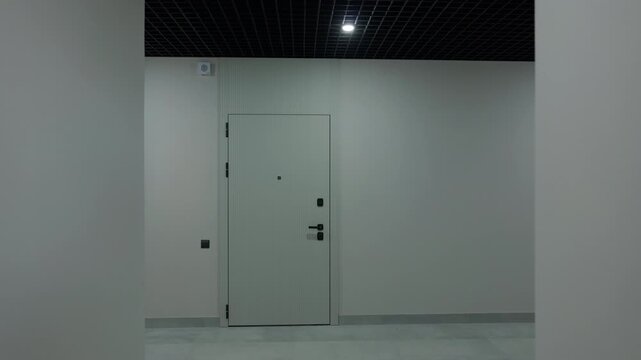 Apartment entrance door at end of modern residential corridor