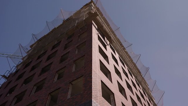 Brick facade of multistory residential building under construction
