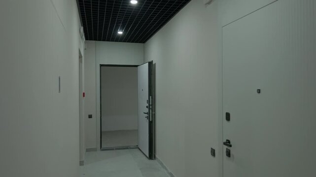Modern residential corridor with apartment entrance doors and grid ceiling