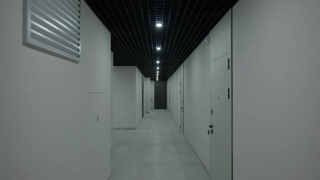 Modern residential corridor with grid ceiling and recessed lighting