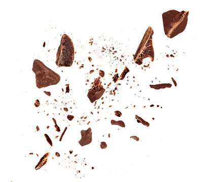 Levitating Dark chocolate crumbs  floating isolated on white background. Grated chocolate pieces  explotion. Chocolate  top view. Flat lay