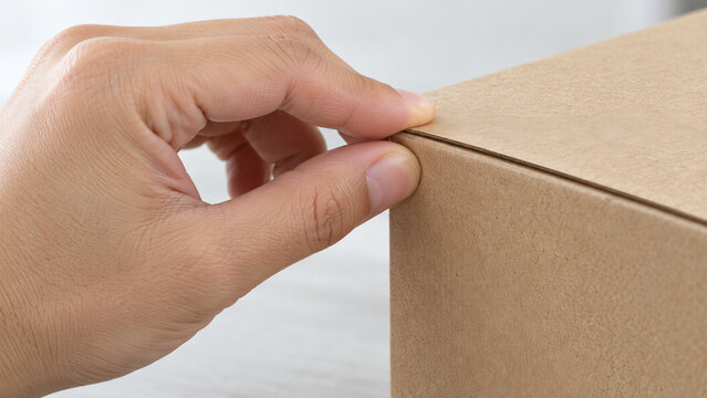 Hand folding cardboard box flap for printed packaging. Printing services and custom box production. Packaging assembly and small business shipping. Recyclable paperboard materials