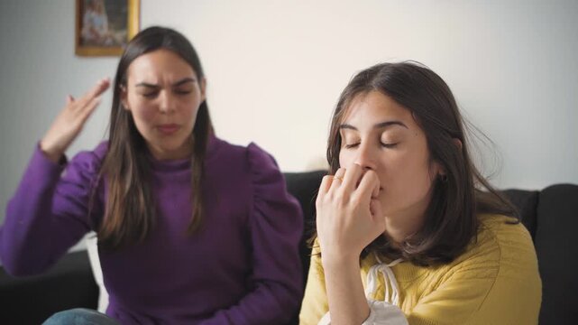 Young Latina woman feeling tired of listening to her friend argue and fight with her. Concept of friendship conflict, emotional exhaustion, interpersonal tension, communication problems, frustration, 