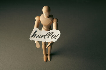 Wooden mannequin holding a piece of paper with the word Hello © Artvibe