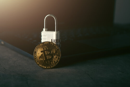 Golden Bitcoin with padlock on laptop computer background. Cryptocurrency concept.