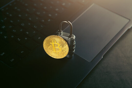 Golden Bitcoin with padlock on laptop computer background. Cryptocurrency concept.