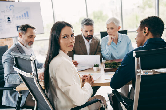 Professional team collaborating in modern office executing innovative corporate strategy and discussing business goals