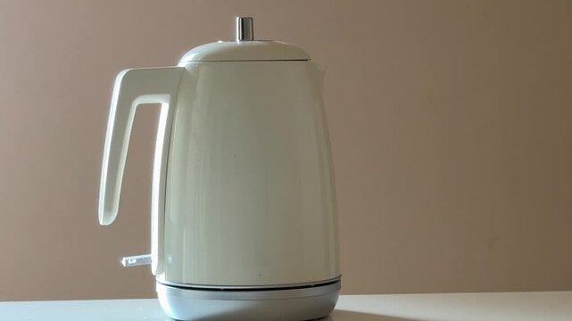 Person Placing Electric Kettle on Base and Turning It on