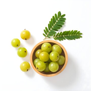 Top view of wooden bowl of  amla fruit on white background