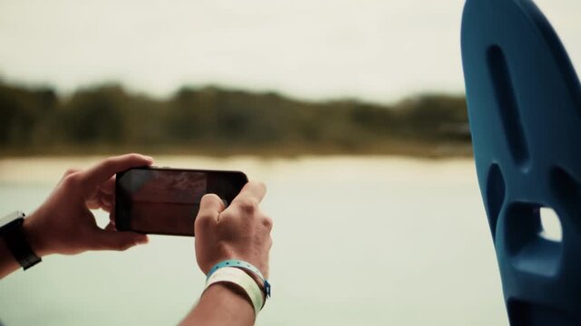 Traveler Using Smartphone To Take Photo Of Scenic Lake View From Boat During Summer Trip