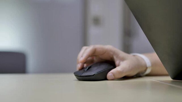 Close-Up of Human Hand Using Wireless Computer Mouse at Office Desk