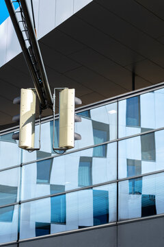 Modern architecture beneath a building overhang with columns glass surfaces and structural elements creating a layered exterior perspective