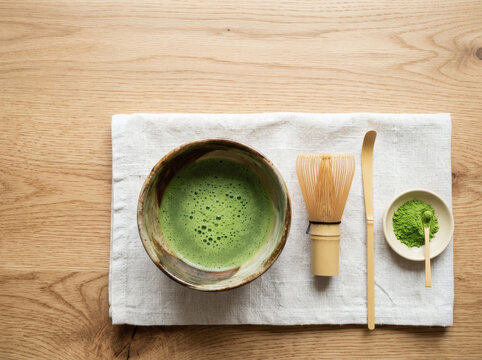 Top view of ceremonial green matcha tea set with bamboo whisk