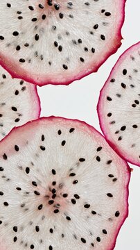 Dragon Fruit Sections Backlit on White in Vertical Luminous Shapes Crop