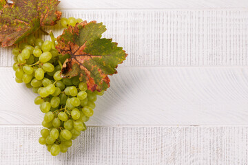 Naklejka premium Ripe grape cluster with seasonal foliage on white boards