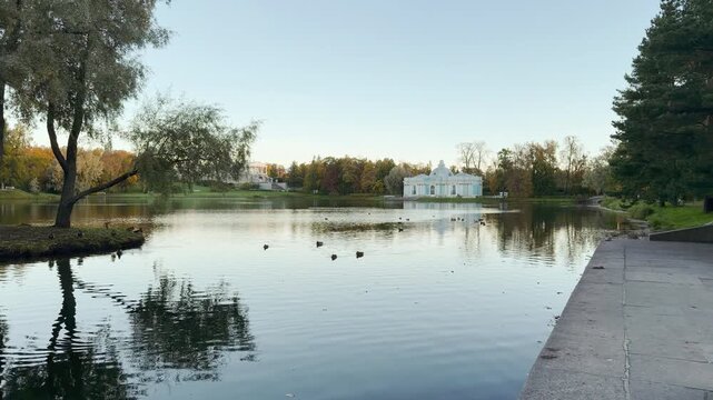 The Grotto Pavilion reflects on the calm lake while ducks swim gently. The tranquil atmosphere brings a feeling of deep peace and warmth. Enjoy autumn in Catherine Park, Pushkin, Saint Petersburg.