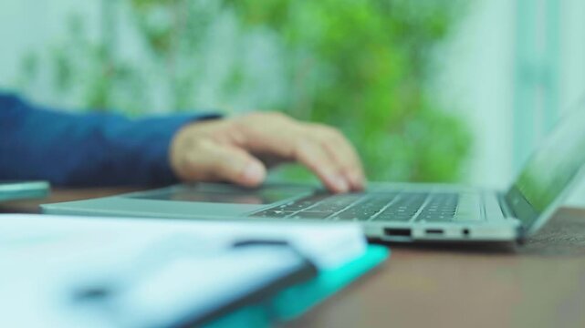 Typing hands manage digital typing tasks on computer hardware, typing notes beside work documents during work hours.