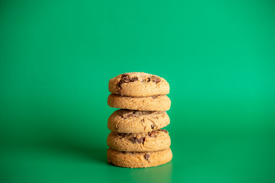 Stack of chocolate chip cookies on vibrant green background