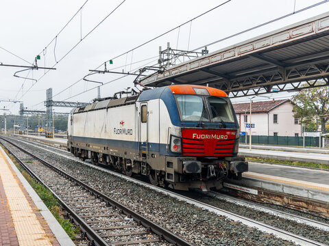 Italy - October 7, 2026: Siemens Vectron electric locomotive (class 191 002) with FuoriMuro livery standing on tracks at an Italian railway station. Industrial freight transportation concept.