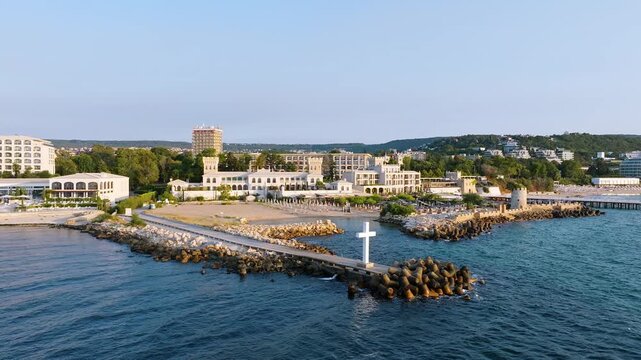 White cross on pier Saints Constantine and Helena resort aerial drone sunrise view Black Sea coast Varna Bulgaria travel footage