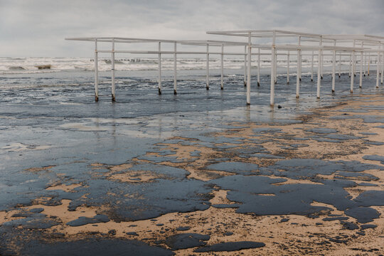 Beach and sea polluted with oil. Beach oil fuel spill impact, pollution, waste disposal.