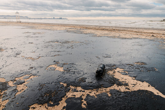 Oil in ocean coastline after a tanker wreck and leakage. Beach is polluted with fuel oil
