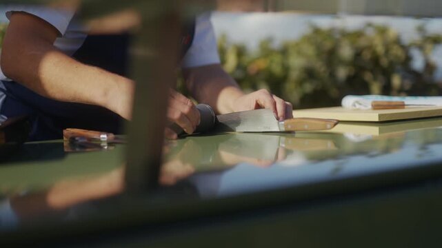 Chef prepares fresh ingredients on a stainless steel outdoor kitchen surface