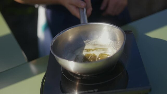 Butter melts on a stainless steel pan on an induction cooktop