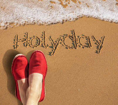 Welle am Strand mit Roten Badeschuhen