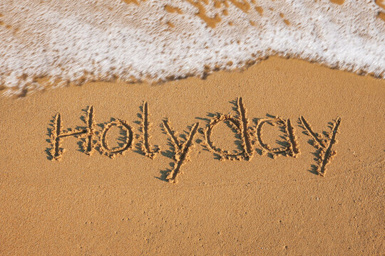 Welle am Strand mit Schrift Holyday