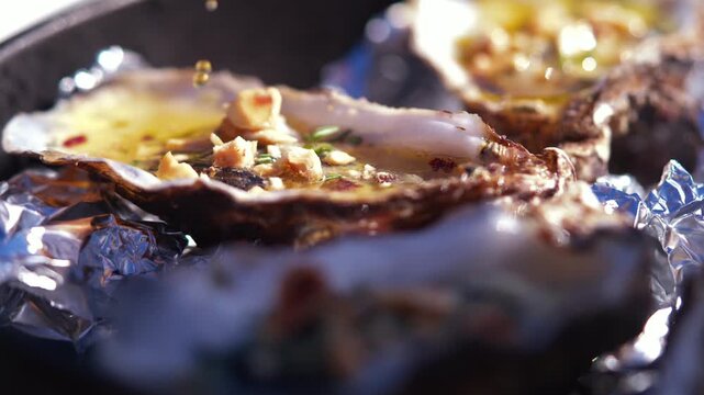 Grilled oysters with garlic butter and herbs on a grill pan